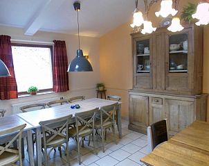 Dining room in La Terra, vacation home in Durbuy, with wooden table and cupboard.