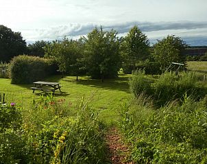 Picnic area in the garden of La Terra vacation home, Durbuy, surrounded by trees.