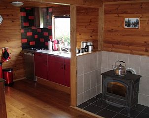 Cozy kitchen with wood stove in Chalet du bois, vacation home in Biron, Ardennes.