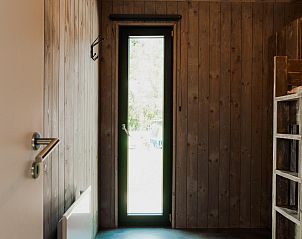 Houten interieur van Eco Lodge MOBIWOOD in La Roche-en-Ardenne, Belgi, met deur naar de natuur van de Ardennen.