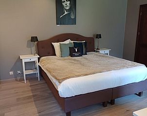 Sfeervolle slaapkamer in Vakantiehuisje in Ereze, Ardennen, Belgi met comfortabel bed en elegante inrichting voor een ontspannen verblijf.