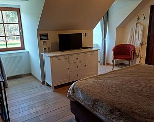 Gezellige slaapkamer in Vakantiehuisje in Ereze, Ardennen, Belgi, met houten vloer en uitzicht op de groene omgeving.