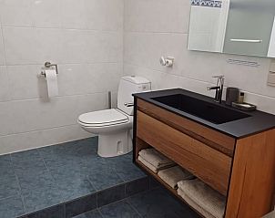 Moderne badkamer in Vakantiehuisje in Ereze, Ardennen, Luxemburg, Belgi met stijlvol wastafelmeubel en toilet.
