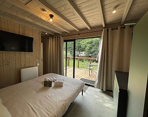 Sfeervolle slaapkamer in Cocoon de la Semois, een vakantiehuis in Bouillon, Ardennen, met uitzicht op het groene terras en omliggende natuur.