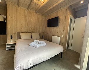 Gezellige slaapkamer in Cocoon de la Semois, vakantiehuis in Bouillon, Ardennen, met houten interieur en comfortabele voorzieningen.
