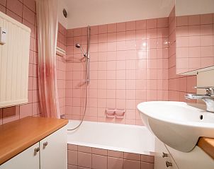 Stilvolles Badezimmer im Apartment Seaview Getaway Belgium, Blankenberge, mit rosafarbenen Fliesen und modernen Annehmlichkeiten an der belgischen Kste.