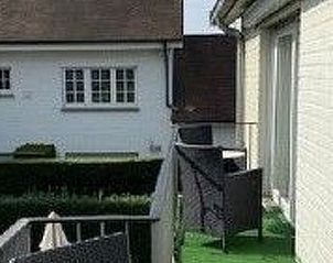 Terrasse des Apartments fr 4 Personen und 1 Kind in Knokke-Heist, belgische Kste, mit Blick auf den Garten und bequemen Sitzgelegenheiten.