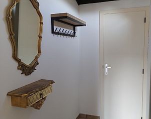 Elegantes Interieur des Ferienhauses Duinenhuisje in Bredene an der belgischen Kste mit antikem Spiegel und rustikalen Details.