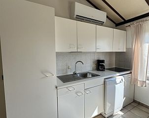 Moderne Kche im Duinenhuisje, einem Ferienhaus in Bredene an der belgischen Kste, mit weien Schrnken und viel natrlichem Licht.