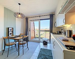 Gezellige keuken en eetruimte in Appartement Blutsyde, Bredene, Belgische kust, met uitzicht op balkon en heldere lucht.