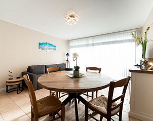 Cozy living room of Apartment Astrid 62/101 in Bredene, Belgian coast. Spacious indoor space with dining table and comfortable seating area.