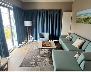 Gezellige woonkamer in Chalet in Bredene, Belgische kust, met comfortabele inrichting en uitzicht op de tuin.