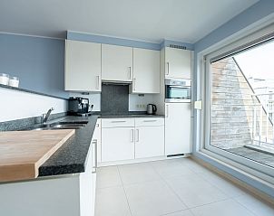 Moderne Kche im Appartement Parklane, Bredene, belgische Kste, mit grozgiger Aufteilung und Blick auf die Terrasse.