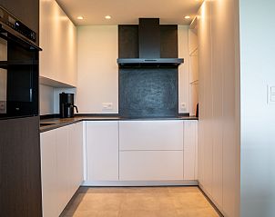 Modern kitchen in Apartment Astrid 68, a vacation rental on the Belgian coast in Bredene, with sleek white cabinets and modern appliances.