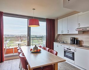 Gezellige keuken en eetruimte in Familiesuite voor 7 personen, Middelkerke, Belgische kust, met uitzicht op terras en natuur.