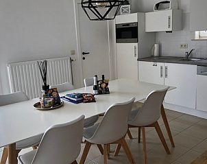 Zee en polder vakantiehuis eetkamer met ruime tafel en stoelen in Lombardsijde, Belgische kust.