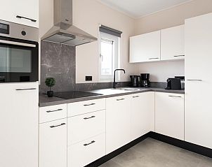 Moderne Kche in Wood Lodge with Airco, einem Ferienhaus in Nieuwpoort an der belgischen Kste, mit eleganten weien Schrnken und Luxusgerten.