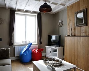 Cozy living room in De Zeebries apartment Ostend with seat cushions and TV.