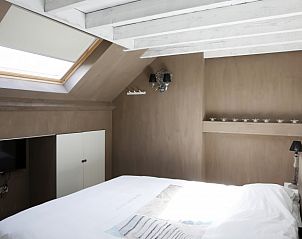 Bright bedroom in De Zeebries apartment Ostend with skylight and TV.