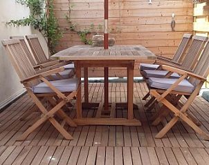 Comfortable terrace in De Zeebries apartment Ostend with wooden garden set.