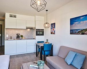 Cozy sitting area in Accessible studio | 2p by the sea, Belgian coast, Belgium with decorative art on the wall.