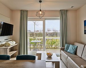 Bright living space in Family Studio on the Belgian coast, with large windows and stunning views of the natural surroundings.