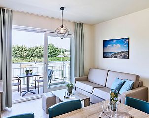 Private terrace of the Family Studio by the sea, Belgian coast, with seating to enjoy the outdoors and the green landscape.