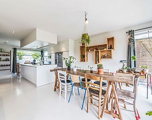 Stijlvolle eetkamer in Vakantiehuis Villa Vosseslag, De Haan, Belgische kust, met moderne keuken en veel natuurlijk licht.