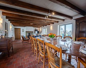 Cozy dining room in Holiday Home Dunezwin, De Haan, Belgian coast, with wooden beams and spacious table, ideal for family gatherings.