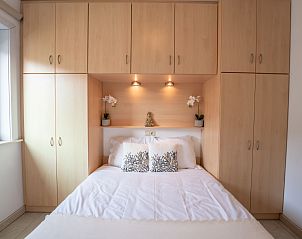 Gemtliches Schlafzimmer im Apartment Green Garden, De Haan, belgische Kste, mit Einbauschrnken und stimmungsvoller Beleuchtung.