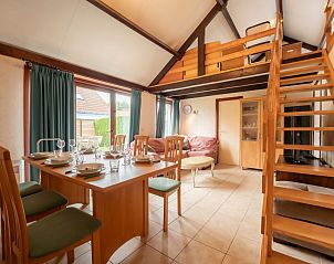 Gemtlicher Innenbereich des Ferienhauses Edelweiss in De Haan an der belgischen Kste, mit Ess- und Sitzecke unter einer hohen Decke.