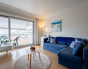 Cozy living room of Apartment Cosy @ the beach studio with pool in De Haan, Belgian coast, with balcony and comfortable seating area.