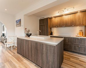 Modern kitchen in Jacamar - De Haan vacation home on the Belgian coast, with wooden cabinets and kitchen island.