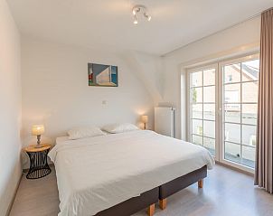 Spacious bedroom in Jacamar - De Haan vacation home, with large bed and access to balcony.