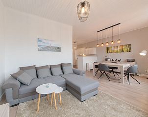 Gemtliches Wohnzimmer im Appartement Carnac Station in De Haan an der belgischen Kste, sonnig und hell, mit modernen Mbeln und bequemer Sitzecke.