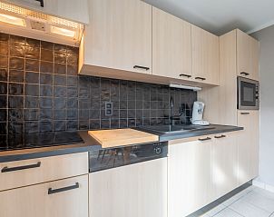 Modern kitchen in Holiday Home Il Passimento in De Haan, Belgian coast, with stylish wooden cabinets and complete appliances.