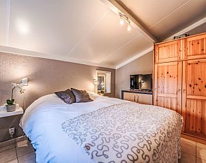 Attractive bedroom in Holiday Home Il Passimento in De Haan, Belgian coast, with comfortable bed and warm wooden accents.