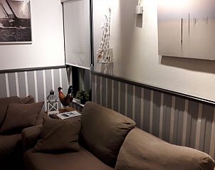 Stylish interior of De Haan Cottage 670 in De Haan, Belgium, with cozy sofa and decoration.