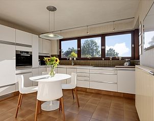 Modern kitchen with dining area in La Maison Fleurie vacation home in Sint-Idesbald, Koksijde on the coast.